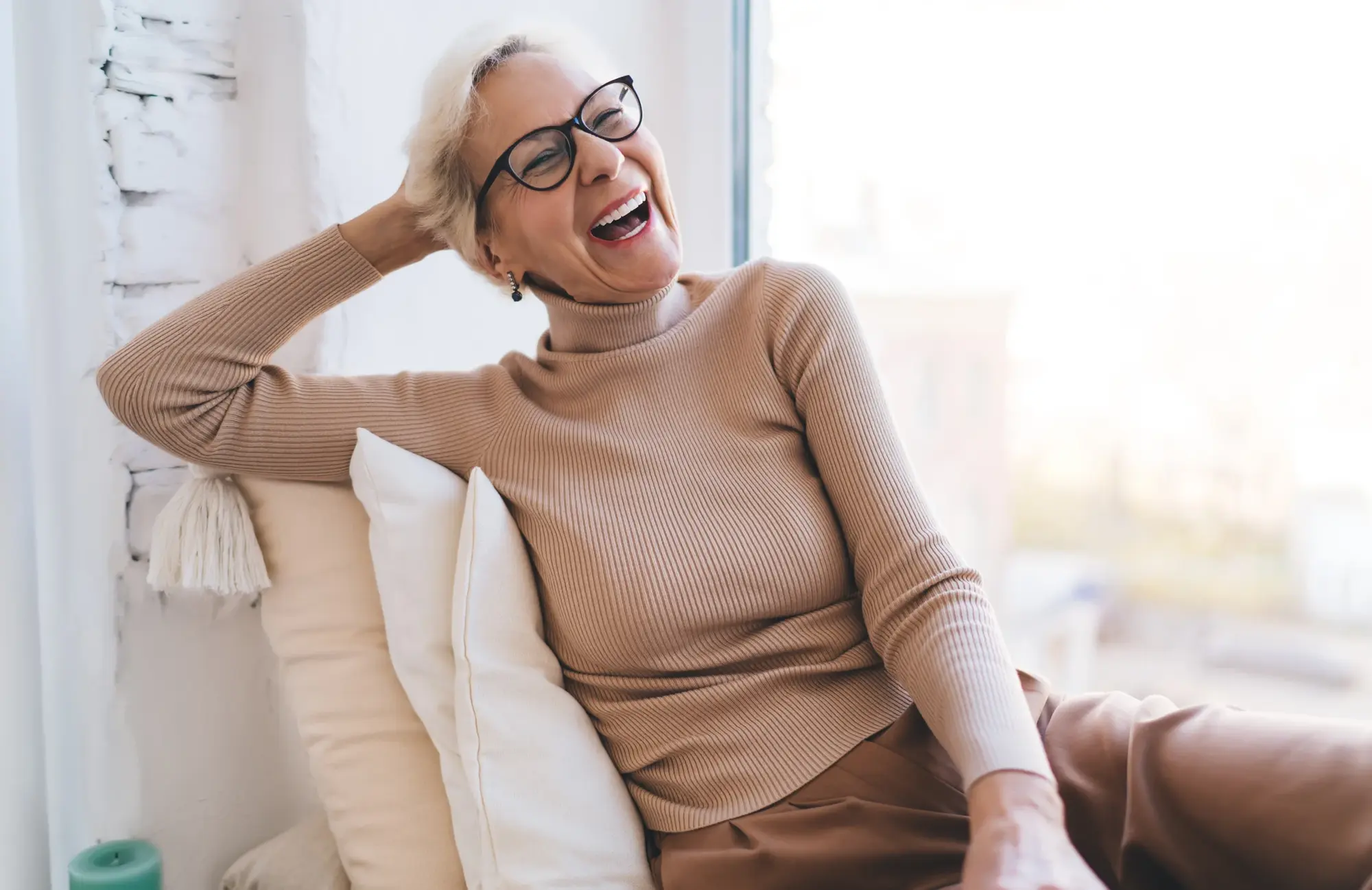 Older woman laughing in a bright room