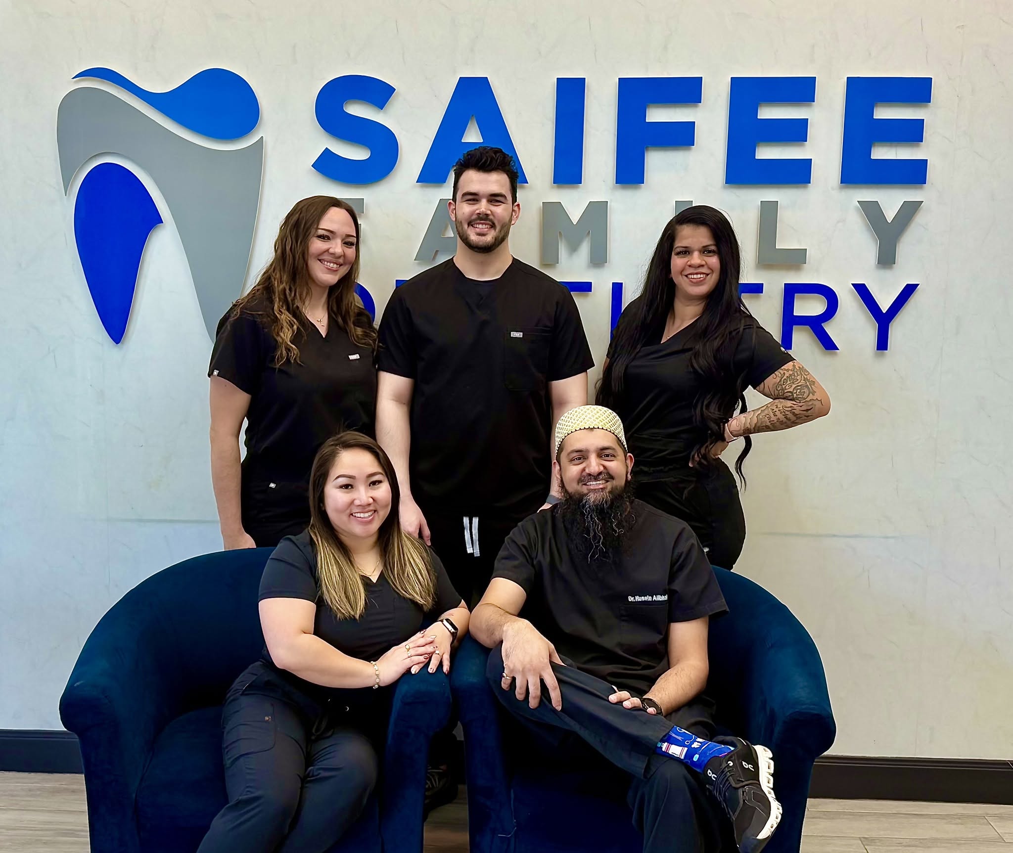 Saifee Family Dentistry team gathered in front of the practice sign